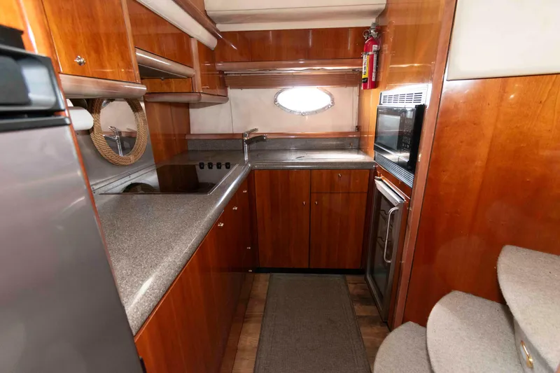 Slide: The Image of Luxurious 2003 Sunseeker Manhattan 56 yacht kitchen with modern appliances and wood cabinetry. - 21