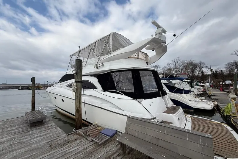 Slide: The Image of 2003 Sunseeker Manhattan 56 yacht docked at marina under cloudy sky. - 3