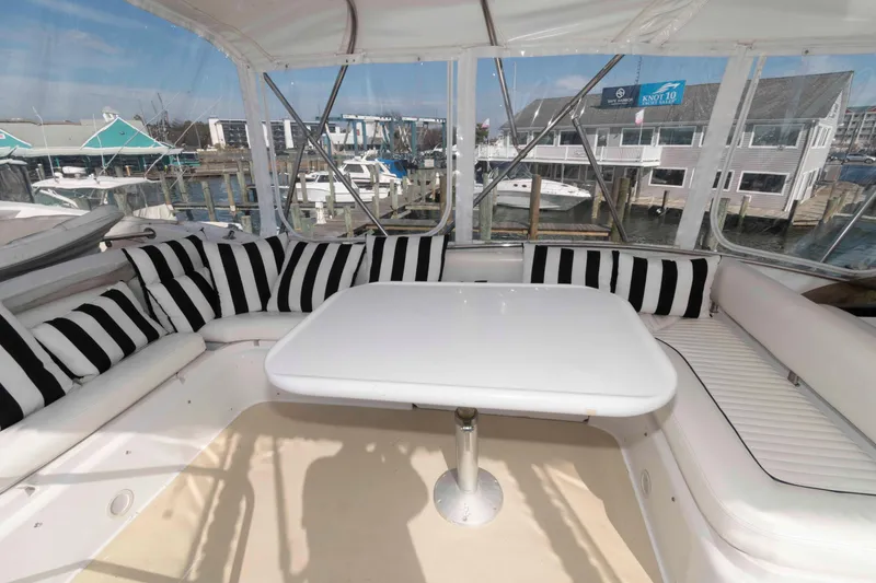 Slide: The Image of Luxurious Sunseeker Manhattan 56 yacht interior with striped cushions, white table, and marina view. - 5