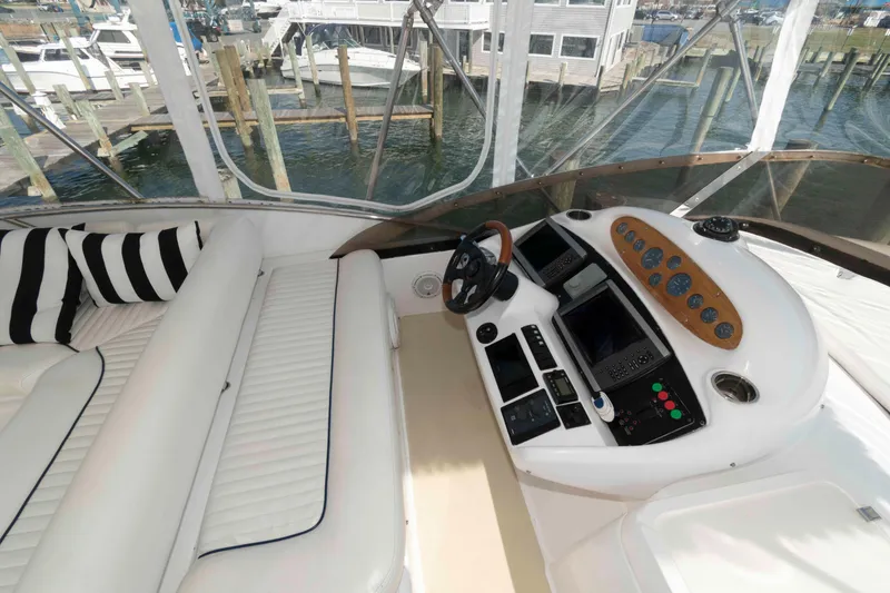 Slide: The Image of Cockpit of 2003 Sunseeker Manhattan 56 yacht with white seating and control panel. - 7