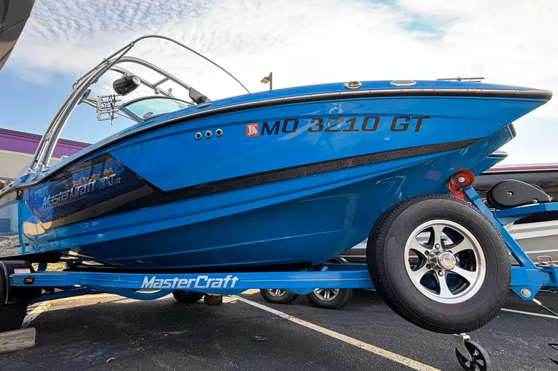 The Image of 2017 MasterCraft NXT20 boat on trailer, vibrant blue, parked outdoors. - 1