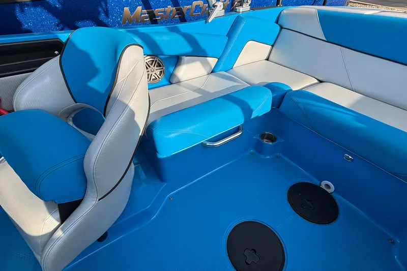 Slide: The Image of 2017 MasterCraft NXT20 boat interior with blue and white seating and speaker. - 13