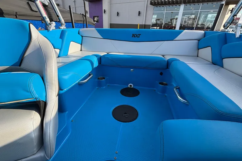 Slide: The Image of 2017 MasterCraft NXT20 boat interior with blue and white seating, cup holders, and sleek design. - 16
