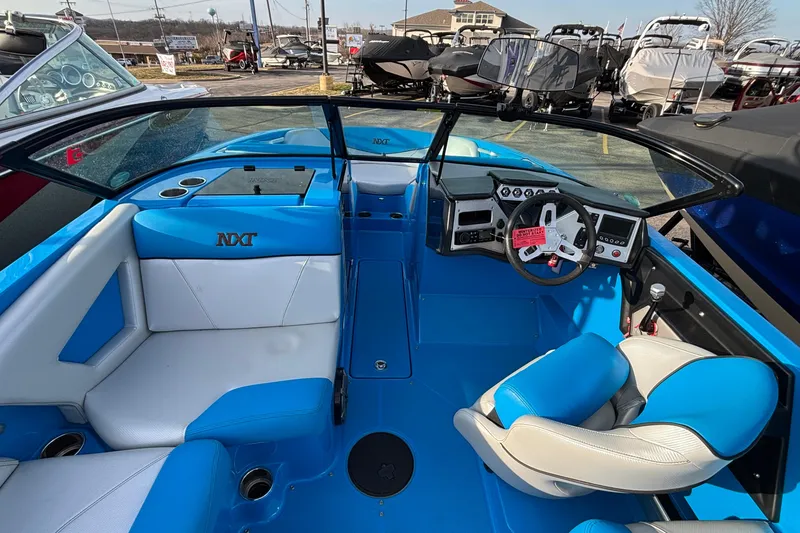 Slide: The Image of 2017 MasterCraft NXT20 boat interior with blue and white seating, steering wheel, and dashboard. - 17