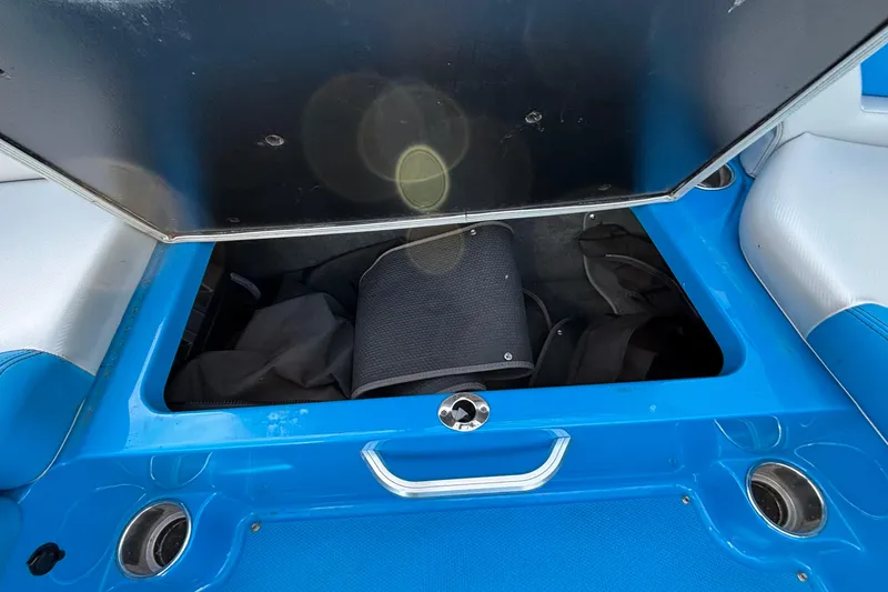 Slide: The Image of Open storage compartment in 2017 MasterCraft NXT20 boat, featuring blue interior. - 18