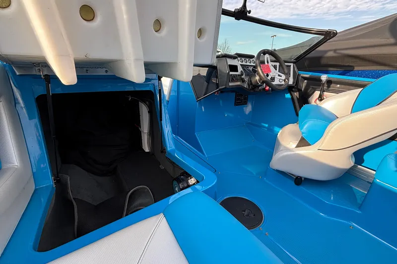 Slide: The Image of 2017 MasterCraft NXT20 interior with blue and white seating, steering wheel, and storage compartment. - 19