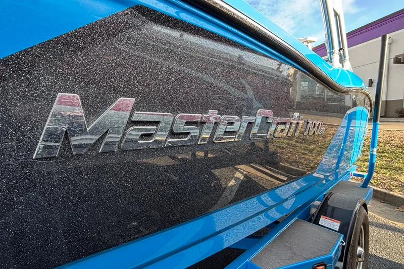 Slide: The Image of 2017 MasterCraft NXT20 boat with metallic finish and logo, parked outdoors. - 8