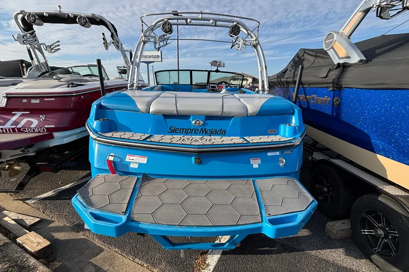 Slide: The Image of 2017 MasterCraft NXT20 boat, blue exterior, parked with other boats, rear view. - 9