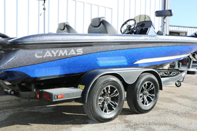 Slide: The Image of 2027 Caymas 201 Pro boat in blue, on a trailer, parked outdoors. - 2