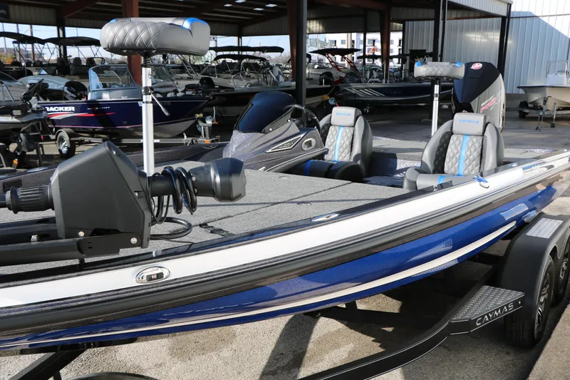 Slide: The Image of 2027 Caymas 201 Pro fishing boat with blue accents in a showroom. - 7