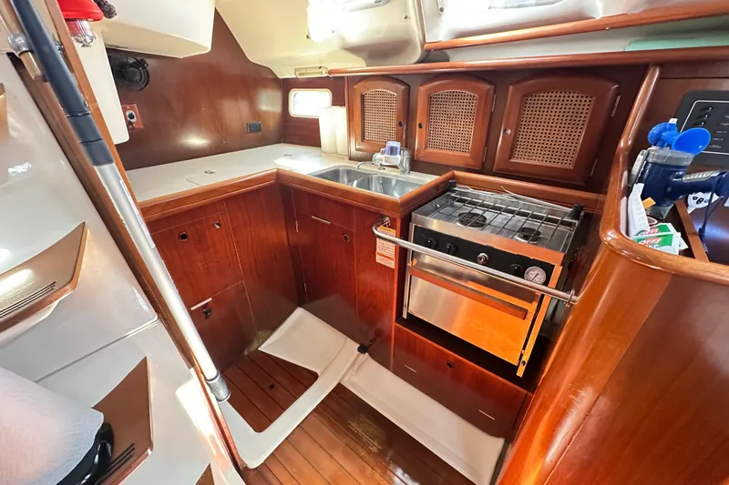 Slide: The Image of 1999 Beneteau Oceanis 352 yacht kitchen with wood cabinetry and stainless steel appliances. - 6