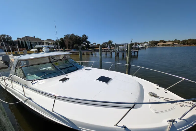 The Image of 1999 Sea Ray 370 Express Cruiser docked by waterfront homes and marina. - 1