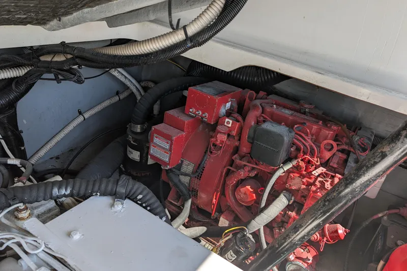 Slide: The Image of Engine compartment of a 1999 Sea Ray 370 Express Cruiser with red engine components. - 16