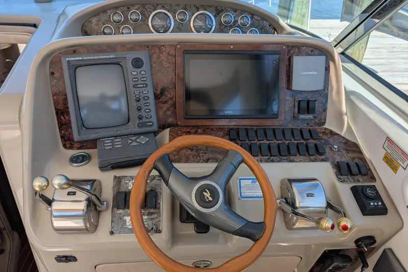 Slide: The Image of 1999 Sea Ray 370 Express Cruiser helm with navigation equipment and wooden steering wheel. - 20