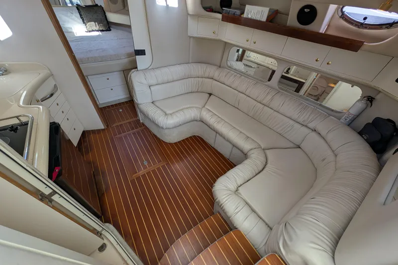 Slide: The Image of Interior of 1999 Sea Ray 370 Express Cruiser with plush seating and wooden flooring. - 22