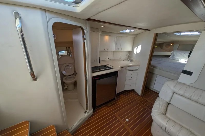 Slide: The Image of Interior of 1999 Sea Ray 370 Express Cruiser with kitchenette, bathroom, and sleeping area. - 23
