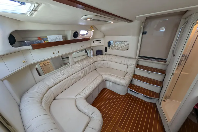 Slide: The Image of Luxurious interior of 1999 Sea Ray 370 Express Cruiser with plush seating and elegant wood flooring. - 26