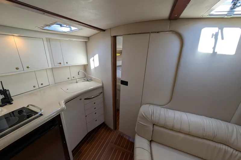 Slide: The Image of Interior of 1999 Sea Ray 370 Express Cruiser with kitchenette and seating area. - 30
