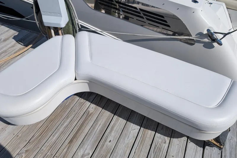 Slide: The Image of White seating on 1999 Sea Ray 370 Express Cruiser, docked on wooden pier. - 32