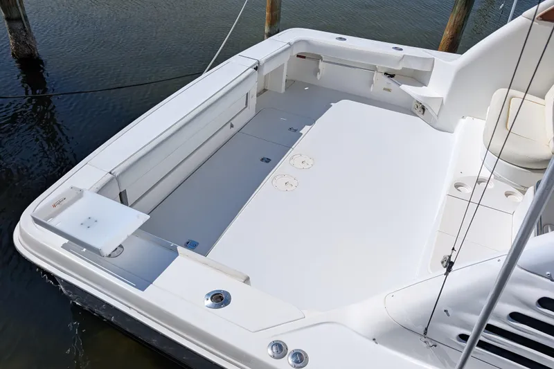 Slide: The Image of 1999 Sea Ray 370 Express Cruiser deck, spacious and well-maintained, docked by the water. - 4