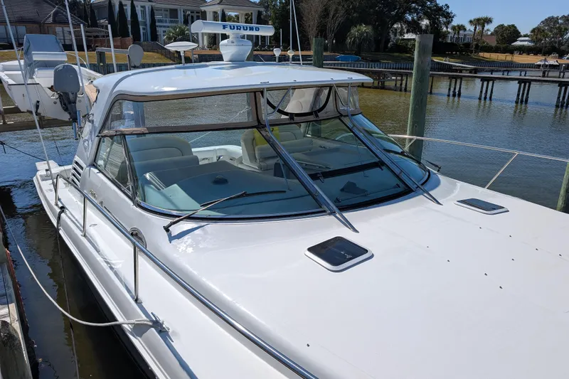 Slide: The Image of 1999 Sea Ray 370 Express Cruiser docked at marina, featuring sleek design and spacious cockpit. - 5