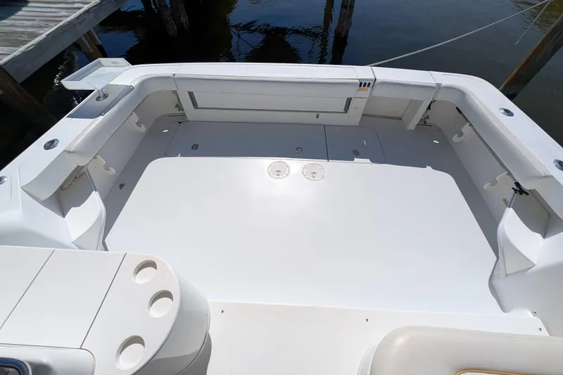 Slide: The Image of 1999 Sea Ray 370 Express Cruiser spacious deck with white seating and storage compartments. - 8