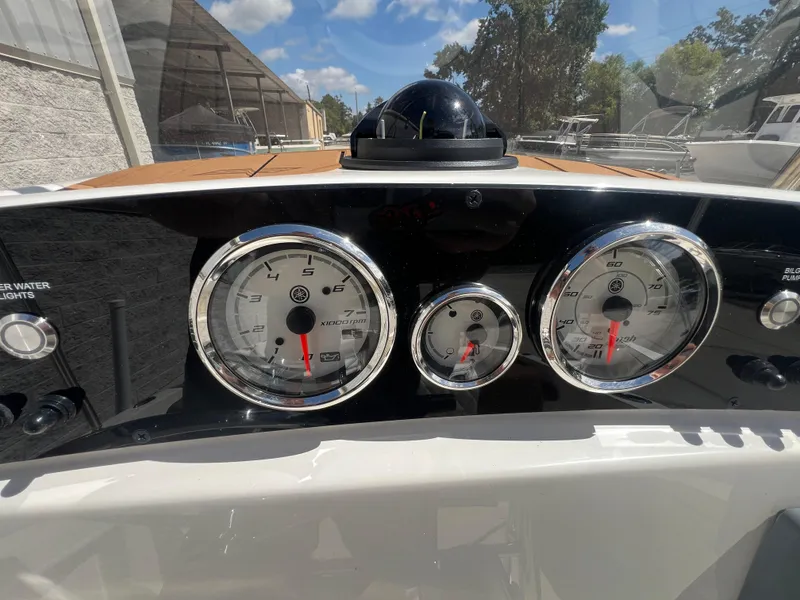 Slide: The Image of Dashboard of 2026 Pioneer 180 Islander boat with gauges and compass under sunny sky. - 10