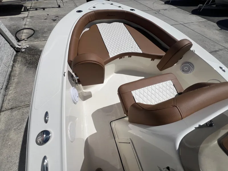 Slide: The Image of 2026 Pioneer 180 Islander boat interior with brown and white seating, docked outdoors. - 15