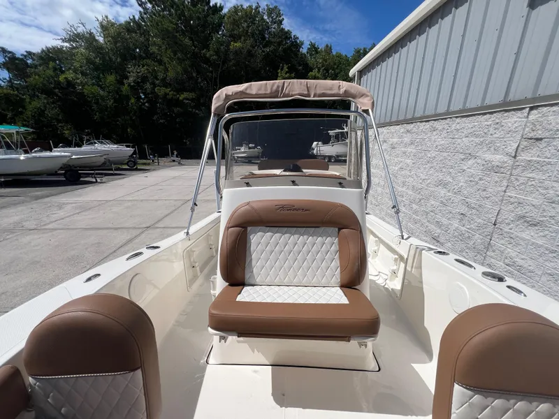 Slide: The Image of 2026 Pioneer 180 Islander boat with tan and white seating, docked outdoors. - 18