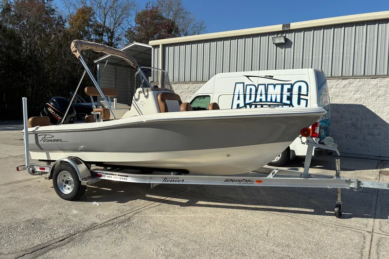 Slide: The Image of 2026 Pioneer 180 Islander boat on trailer, parked outside a building. - 2