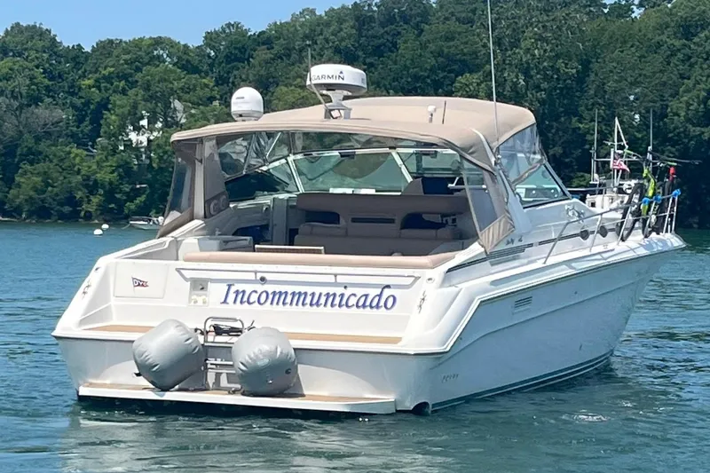 Slide: The Image of Sea Ray 440 Sundancer 1995 boat named "Incommunicado" on a serene lake. - 1