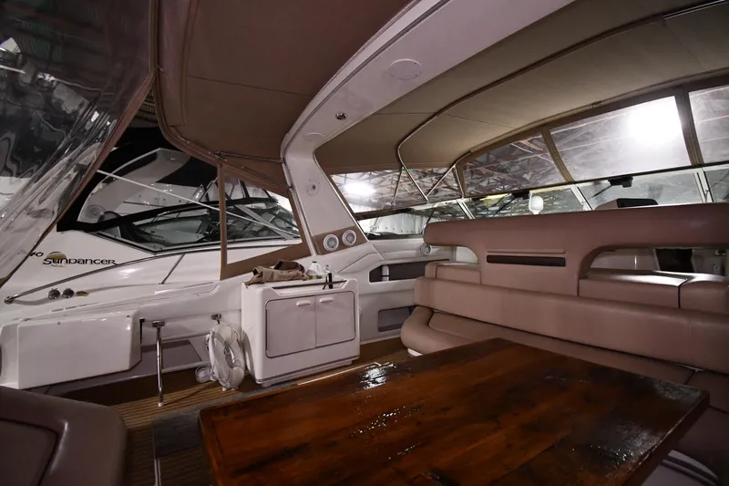 Slide: The Image of 1995 Sea Ray 440 Sundancer interior with beige seating and wooden table. - 13