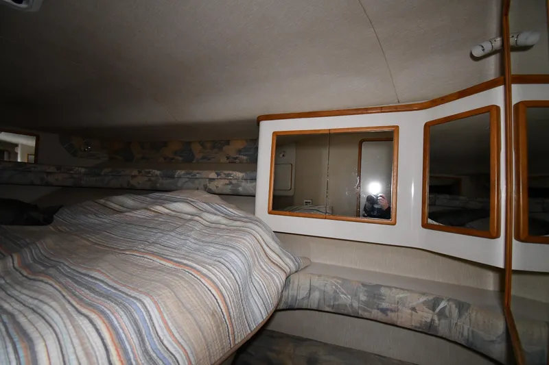 Slide: The Image of Interior cabin of 1995 Sea Ray 440 Sundancer with mirrors and striped bedding. - 21