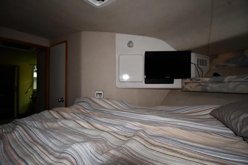 Slide: The Image of Cozy cabin interior of 1995 Sea Ray 440 Sundancer with bed and TV. - 23
