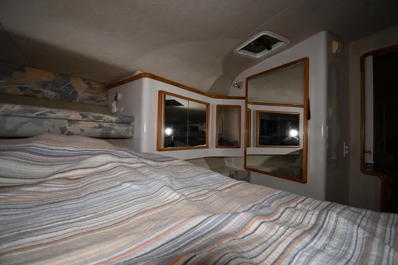 Slide: The Image of Interior cabin of 1995 Sea Ray 440 Sundancer with mirrors and striped bedding. - 24