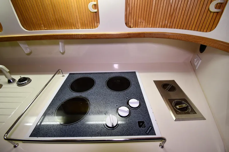 Slide: The Image of 1995 Sea Ray 440 Sundancer kitchen with stovetop and wooden accents. - 37