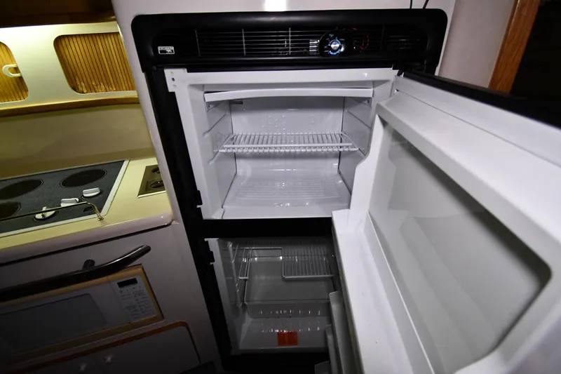 Slide: The Image of Open refrigerator in 1995 Sea Ray 440 Sundancer yacht kitchen, showing empty shelves. - 39