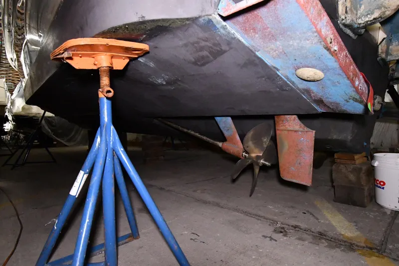 Slide: The Image of 1995 Sea Ray 440 Sundancer boat under maintenance, showing propeller and support stand. - 54