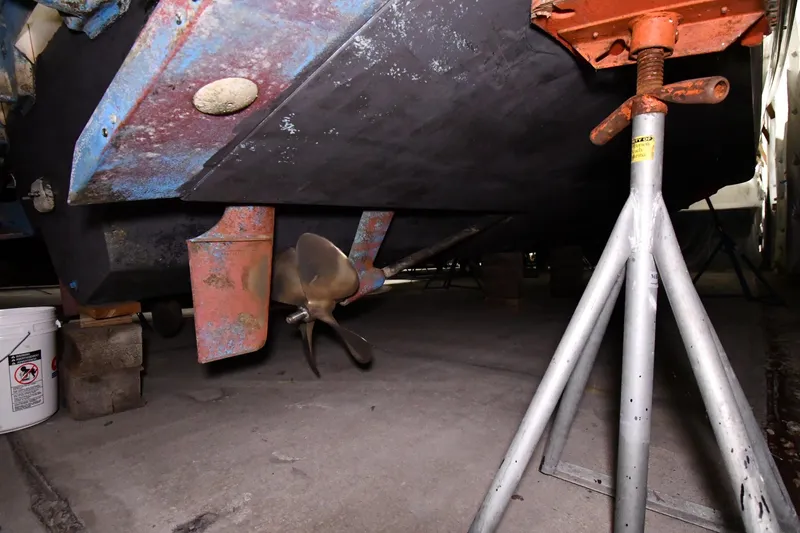 Slide: The Image of 1995 Sea Ray 440 Sundancer under maintenance, showing propeller and support stands. - 55