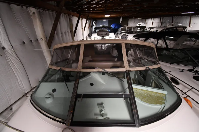 Slide: The Image of 1995 Sea Ray 440 Sundancer yacht stored indoors, showcasing cockpit and windshield. - 7