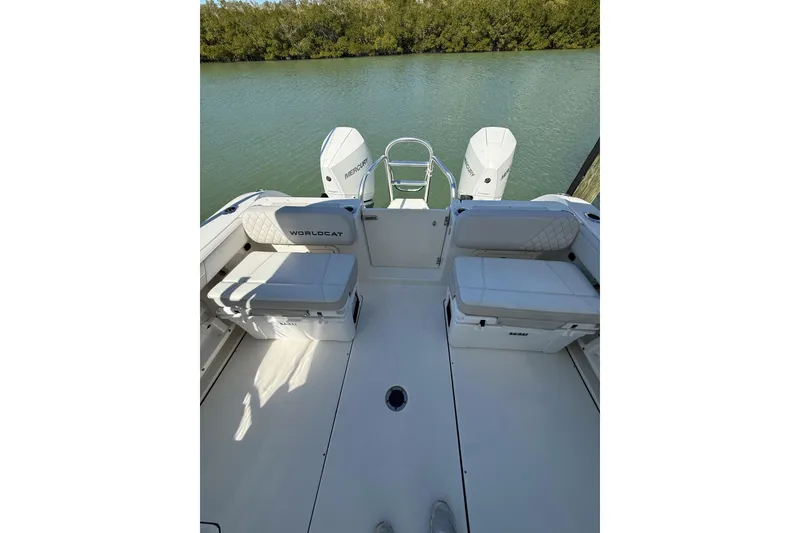 Slide: The Image of 2024 World Cat 296 DC boat interior with seating and twin Mercury engines. - 2