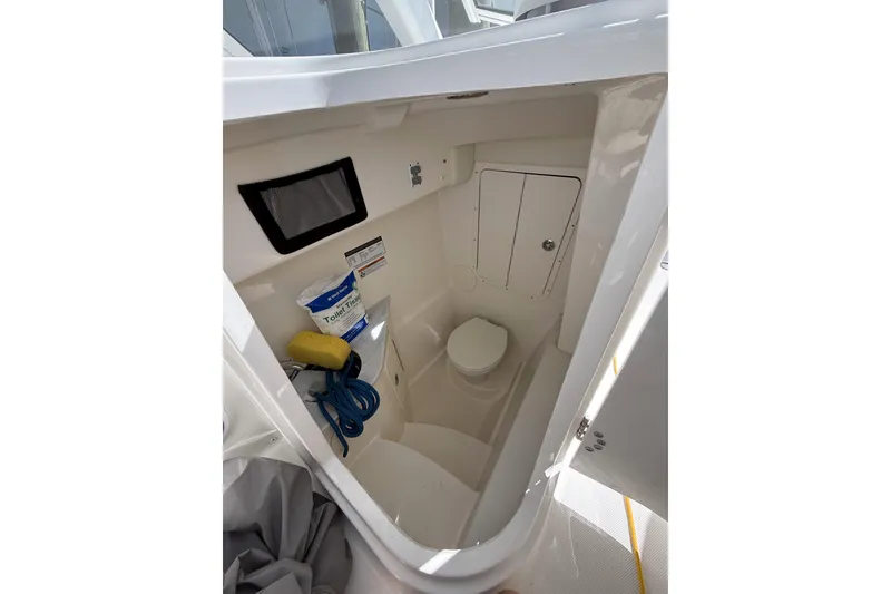Slide: The Image of 2024 World Cat 296 DC boat interior with compact marine toilet and storage. - 20