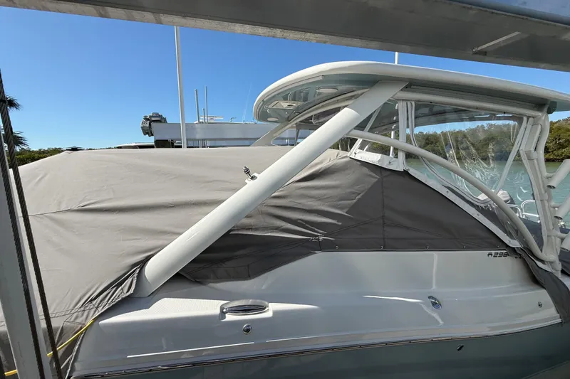 Slide: The Image of 2024 World Cat 296 DC boat with protective cover, docked by the water. - 28