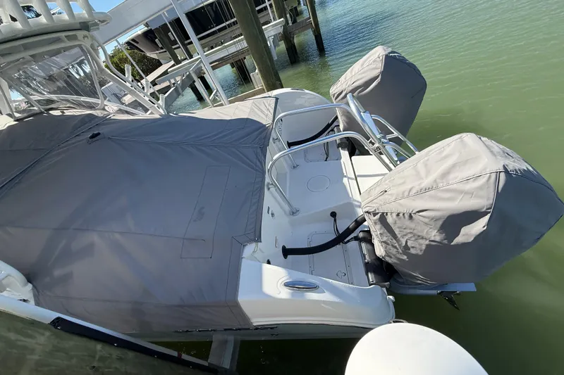 Slide: The Image of 2024 World Cat 296 DC boat with covered engines docked on calm water. - 29