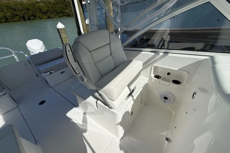 Slide: The Image of 2024 World Cat 296 DC boat interior with cushioned seating and cup holders. - 9