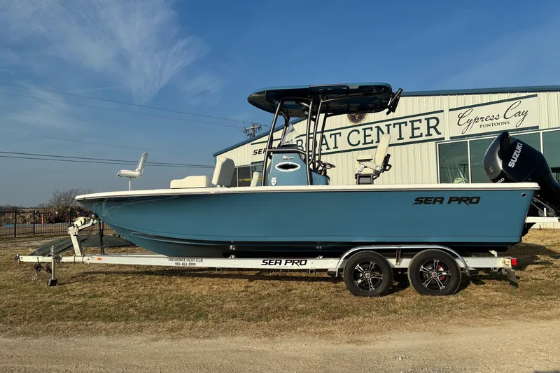 The Image of 2026 Sea Pro 250 Bay boat on trailer, parked outside a boat center. - 0