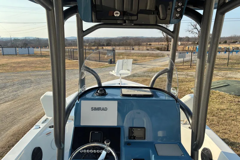 Slide: The Image of 2026 Sea Pro 250 Bay boat dashboard with Simrad navigation system, outdoor setting. - 12