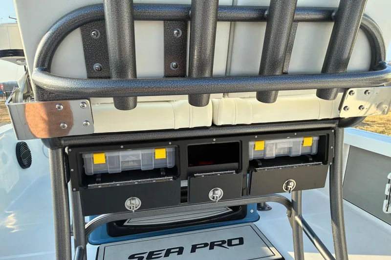 Slide: The Image of 2026 Sea Pro 250 Bay boat storage compartments with tackle boxes and cushioned seating. - 19