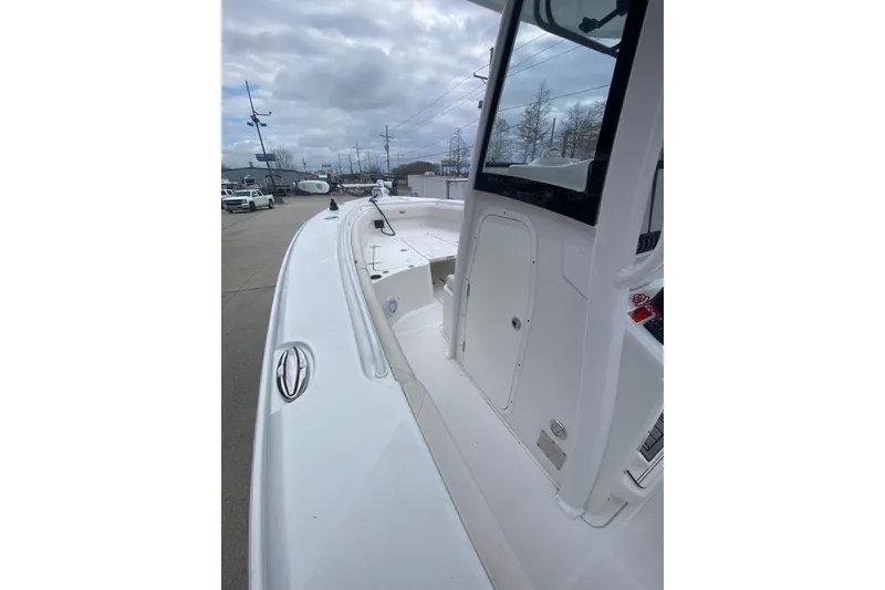 Slide: The Image of 2021 Sea Hunt Gamefish 27 Forward Seating boat, side view, docked under cloudy sky. - 17
