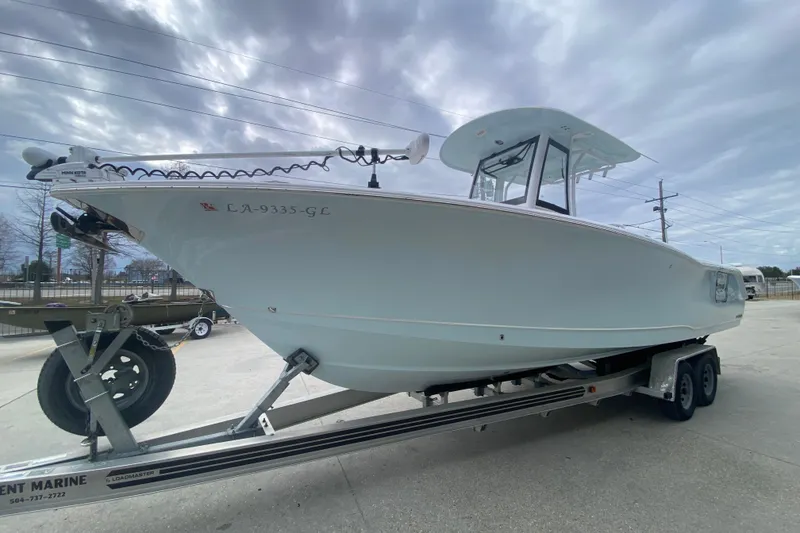 Slide: The Image of 2021 Sea Hunt Gamefish 27 Forward Seating boat on trailer under cloudy sky. - 7